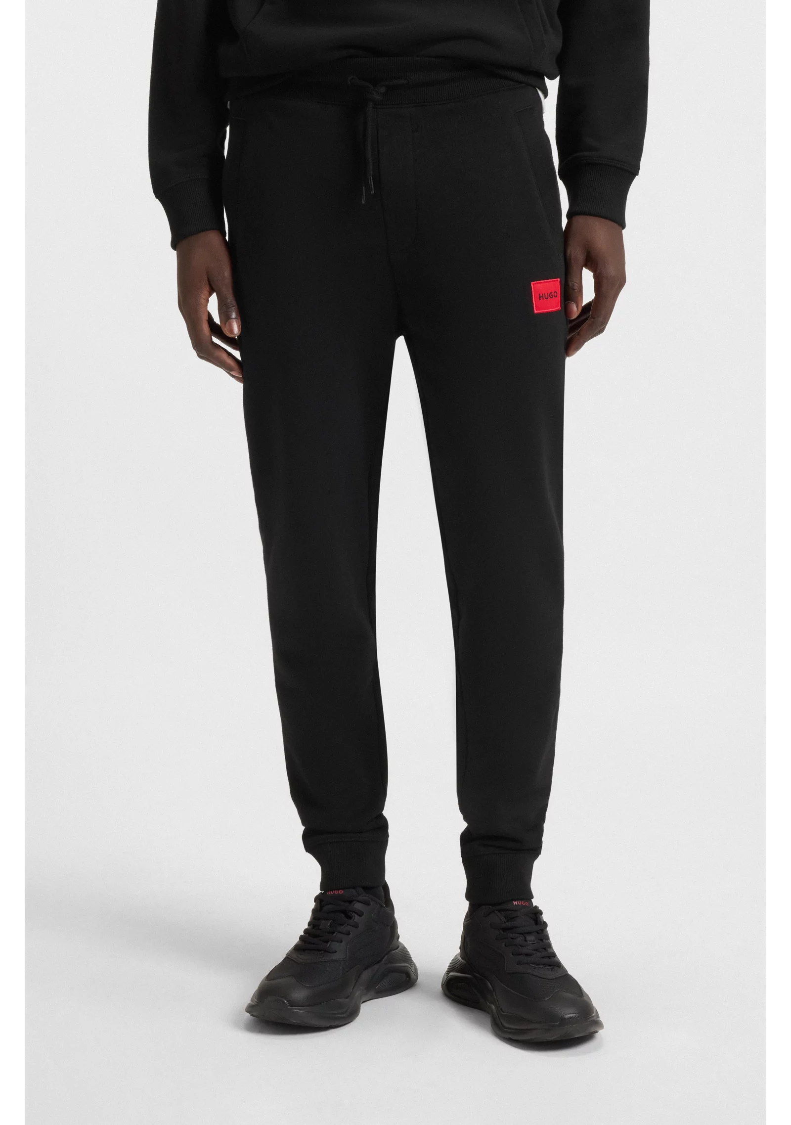 hbeu50447963_001_350 Cotton-terry tracksuit bottoms with red logo label - Image 1